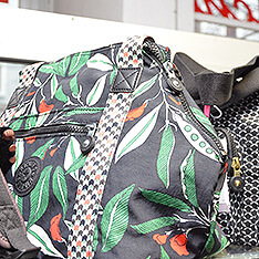 Eine schwarze Tasche mit Blätter-Muster